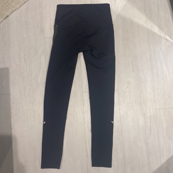 These are black leggings with a green streak and a star on both sides - Picture 2 of 3